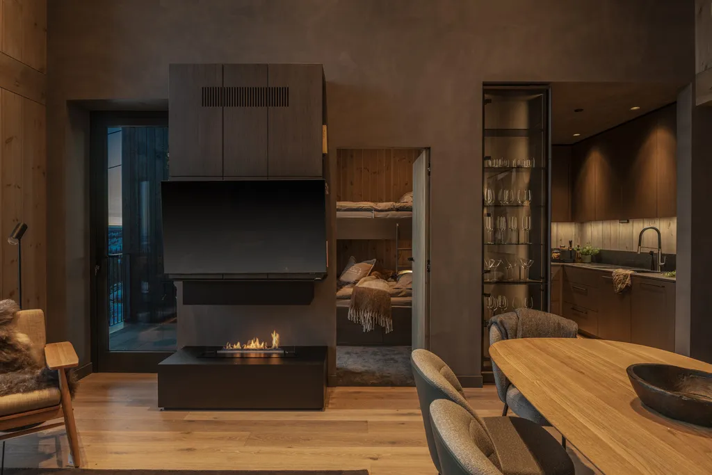 Apartment B22, Kvitfjell, Norway: fireplace, kitchen and dining area with the bunk bedroom beyond