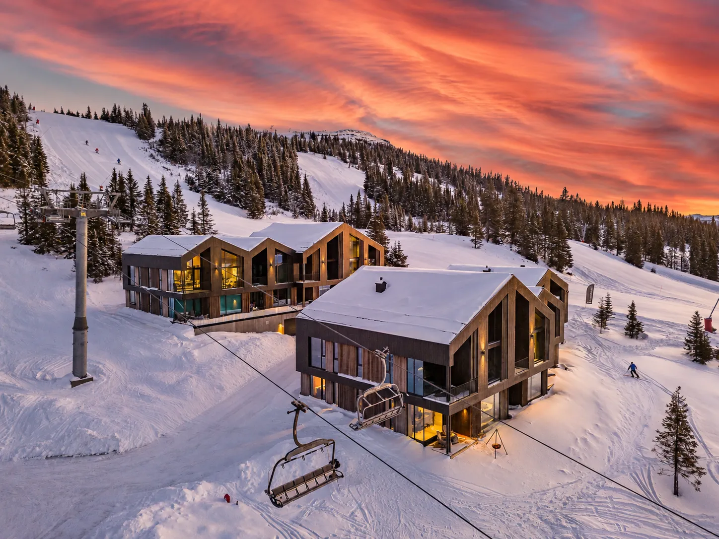 The slopeside apartment development at Kvitfjell West beneath a red sunset sky